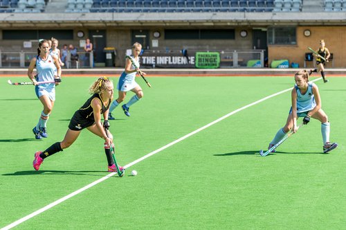 Several female hockey players in action during a match